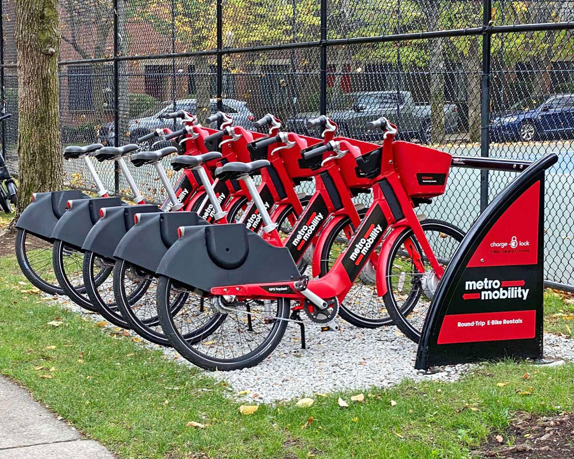 Metro Mobility e-bikes at ChargeLock station on grass and gravel surface