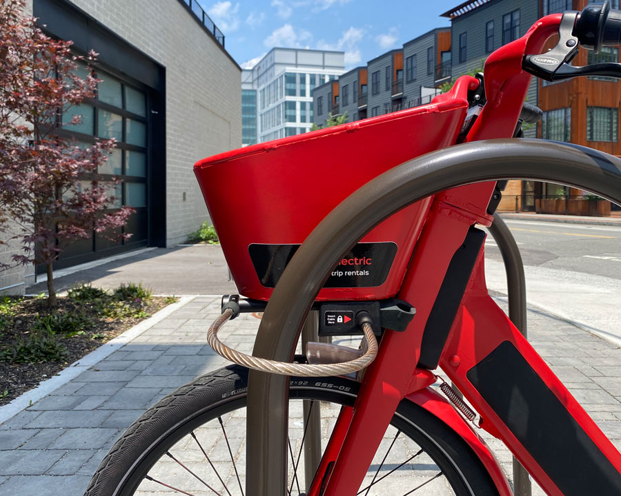 Metro Mobility e-bike built-in cable lock secured to a bike rack