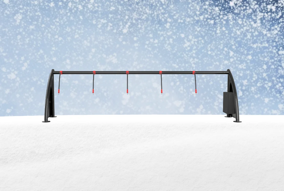 A ChargeLock station in falling snow, cables hanging clear of the drift